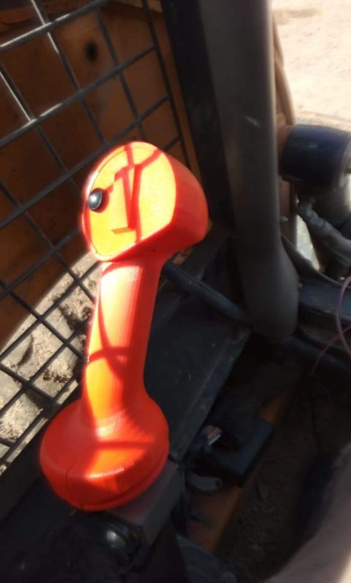 Carcasa roja fabricada e instalada en la palanca de la minicargadora
